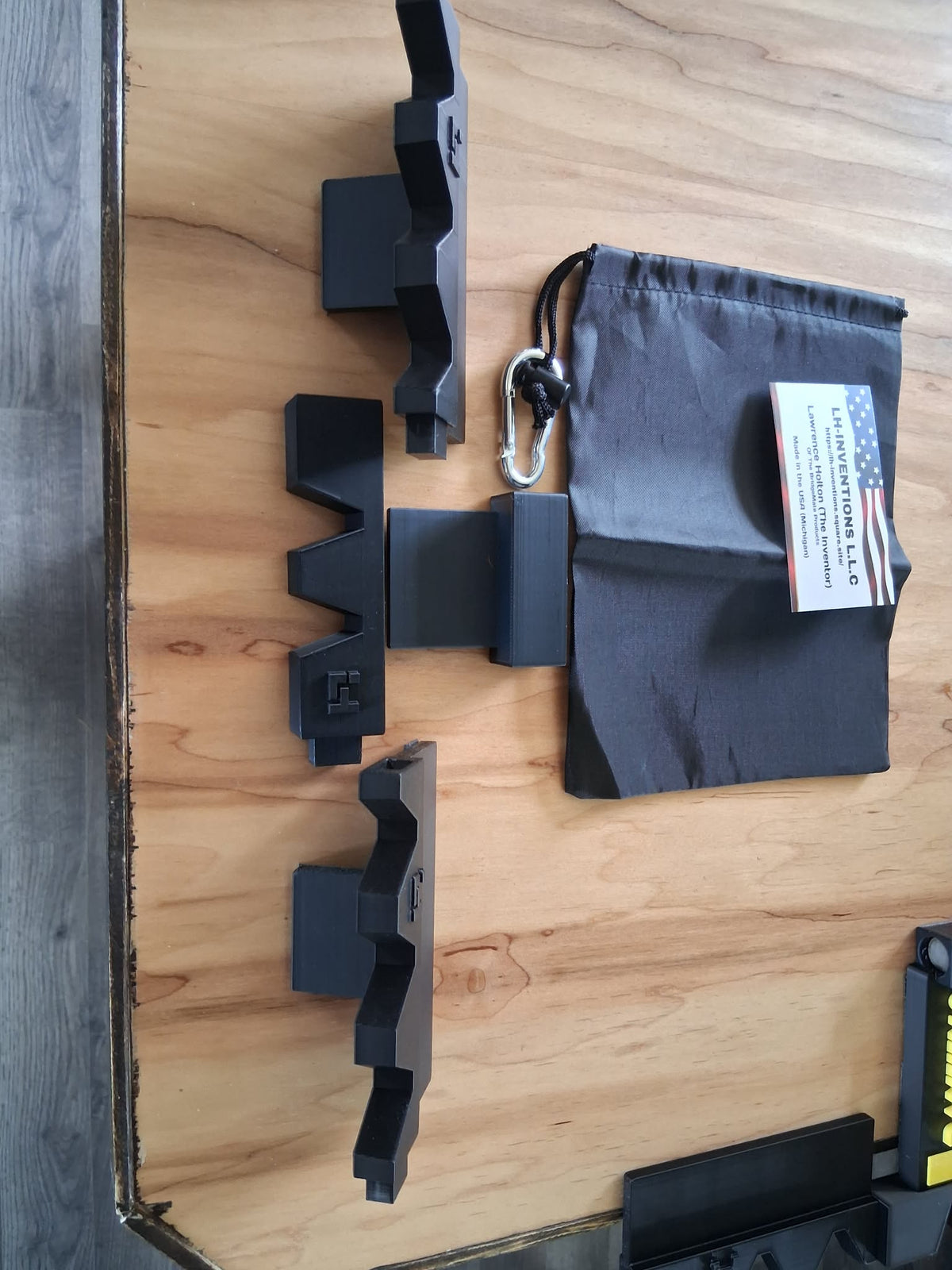 Endless Cue Holder black 3D-printed expandable pool cue rack modules linked together on wood surface — LH Inventions modular billiard cue holder with carry bag